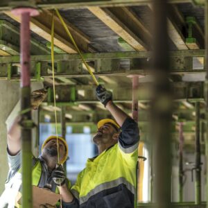 Construction workers measuring building